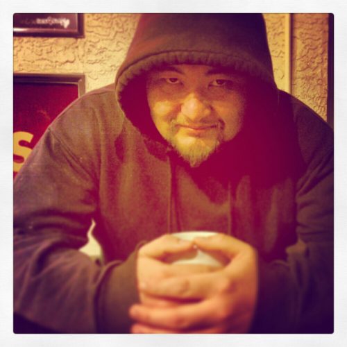 Billy puts his hoody up and holds his warm coffee on a cool night in Cook Street Village, Mocha House
