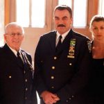 The Reagan family stand in full NYPD uniform in the light of the Catholic Church