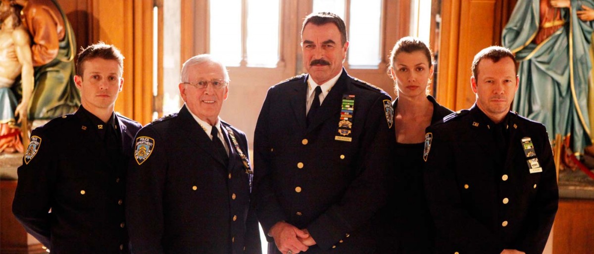 The Reagan family stand in full NYPD uniform in the light of the Catholic Church