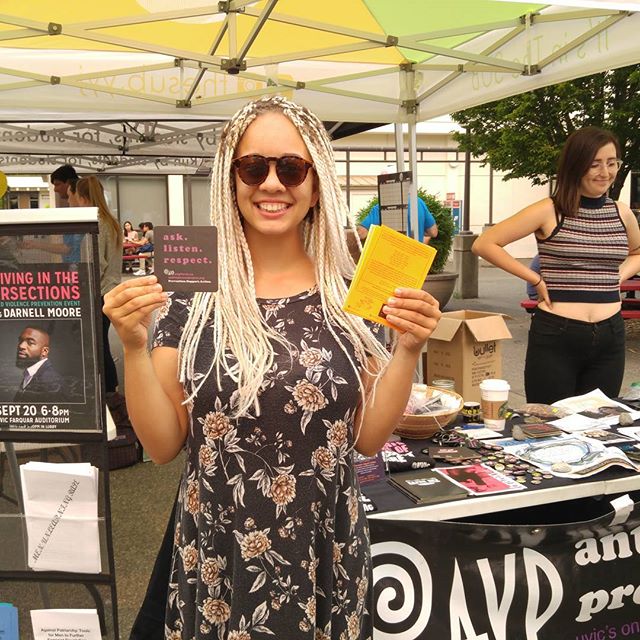 A volunteer stands out in front of the AVP table in the fall at UVic.