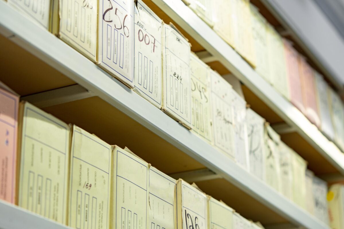 Boxes of well organized and well marked stuff lines shelves in a wharehouse.